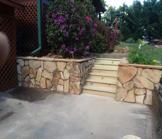 Retaining wall with stone applied over cross-ties. Wire mesh mortar, and stone. 