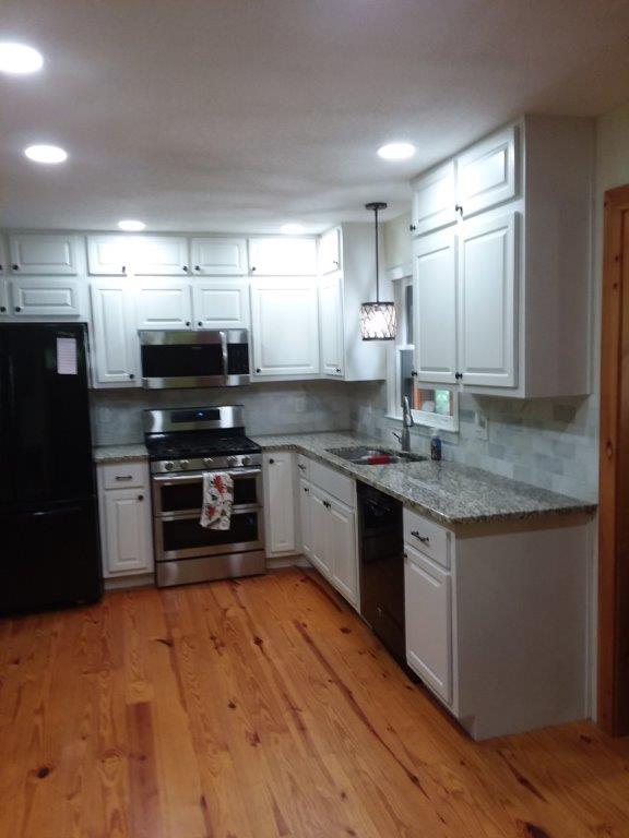 Finished kitchen 9 - Painted knotty pine wood cabinets with granite top, tile backsplash and knotty pine wood flooring.